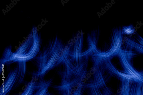 Wallpaper with bright curved lines and flame of blue color. Background with copy space for screen or banner text. Lightpainting effect