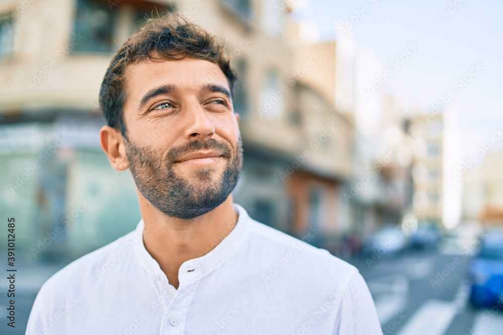 Handsome man with beard wearing casual white shirt on a sunny day smiling happy outdoors Handsome man with beard wearing casual white shirt on a sunny day smiling happy outdoors