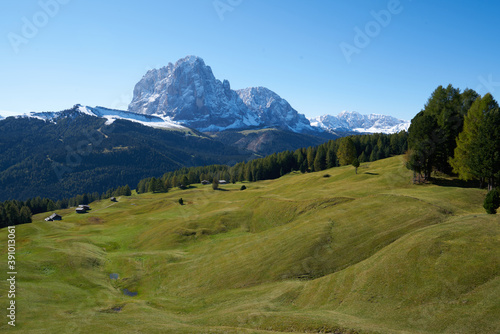 Beautiful langkofel mountain in the dolomites seen from the seceda alm with the first snow white and blue sky photo