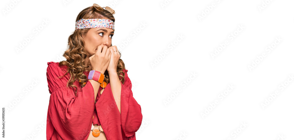 Young blonde girl wearing bohemian and hippie style looking stressed and nervous with hands on mouth biting nails. anxiety problem.