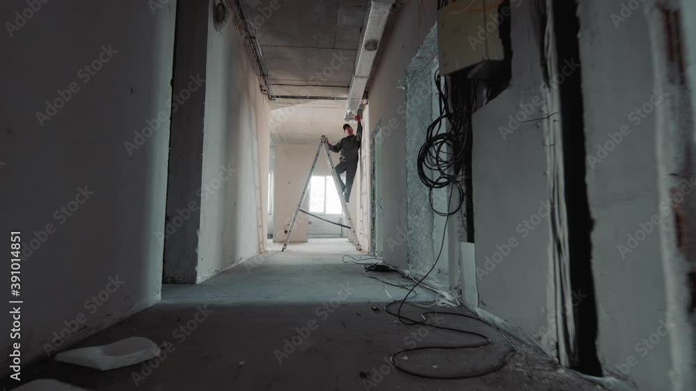 Silhouette of a construction worker laying ventilation ducts. Worker ...