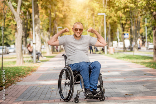 Handicapped man in wheelchair walk at the park alley
