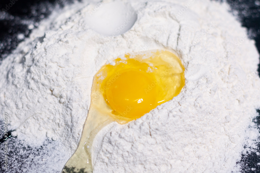 A broken chicken egg on a stack of white flour in the center of the screen. A broken chicken egg on a stack of white flour in the center of the screen.