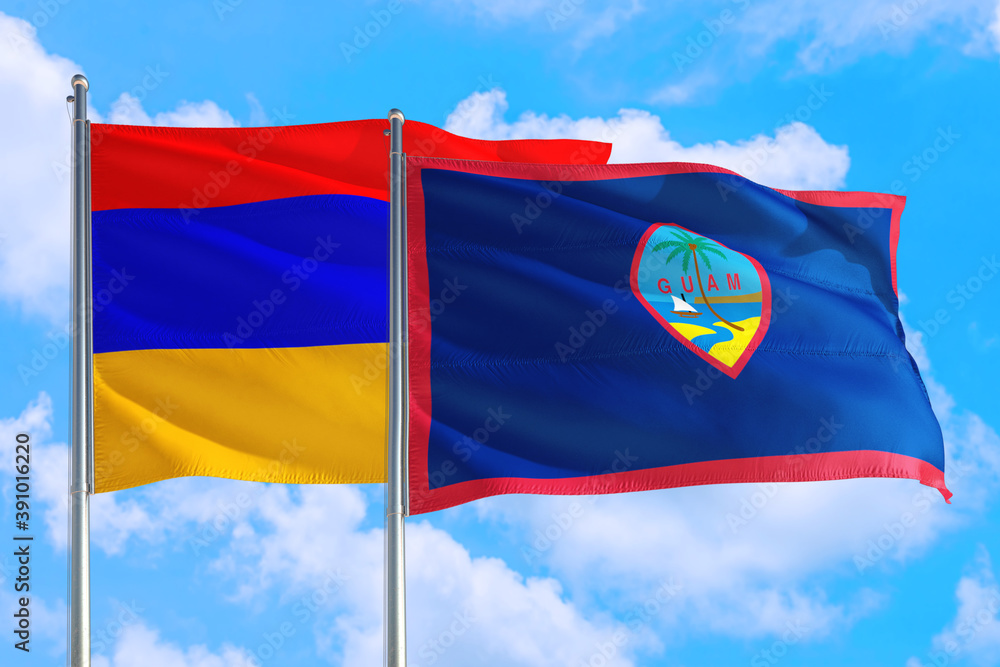 Guam and Armenia national flag waving in the windy deep blue sky. Diplomacy and international relations concept. Guam and Armenia national flag waving in the windy deep blue sky. Diplomacy and international relations concept.