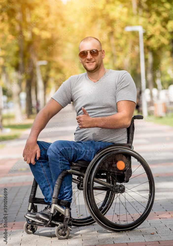 Handicapped man in wheelchair walk at the park alley Handicapped man in wheelchair walk at the park alley