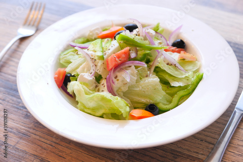 Close up of greek salad in a bowl on table.