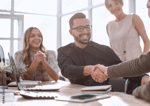 happy business colleagues shaking hands with each other.