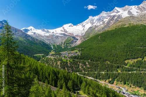 Panoramic summer view of Saas-Fee holiday village and surrounding mountains from Saas-Grund, Valais, Switzerland.