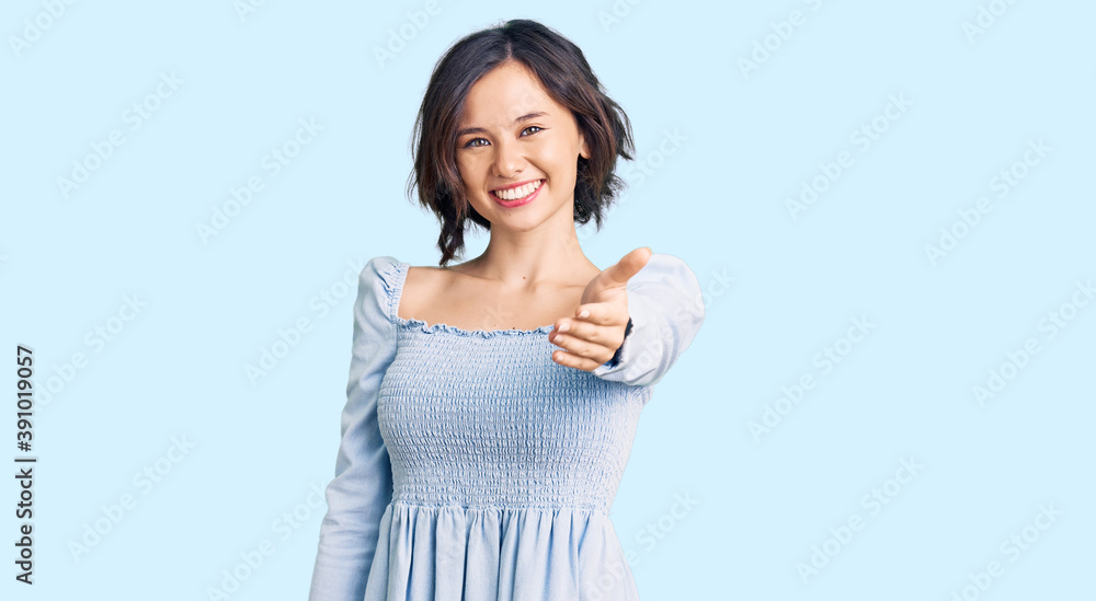 Young beautiful girl wearing casual clothes smiling cheerful offering palm hand giving assistance and acceptance. Young beautiful girl wearing casual clothes smiling cheerful offering palm hand giving assistance and acceptance.