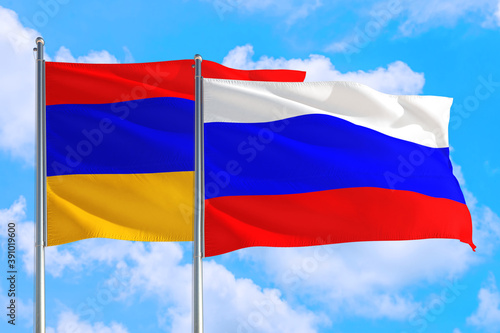 Russia and Armenia national flag waving in the windy deep blue sky. Diplomacy and international relations concept.