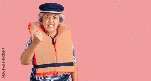 Senior woman with gray hair wearing nautical lifejacket annoyed and frustrated shouting with anger, yelling crazy with anger and hand raised photo