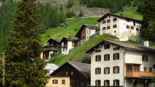 Swiss chalet houses on mountain slope.