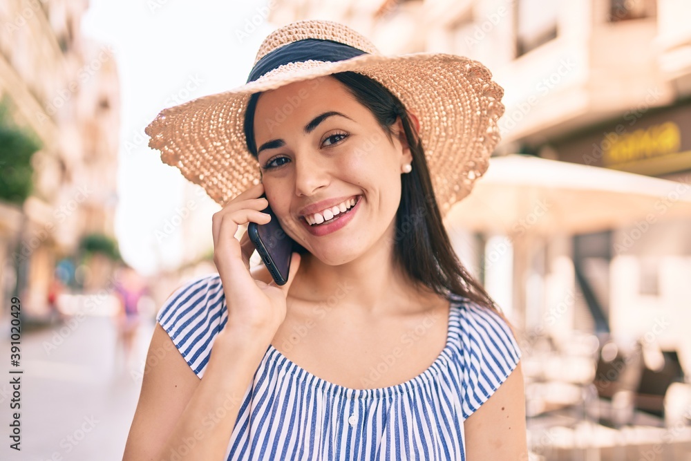 Young latin tourist girl on vacation smiling happy  talking on the smartphone at the city.