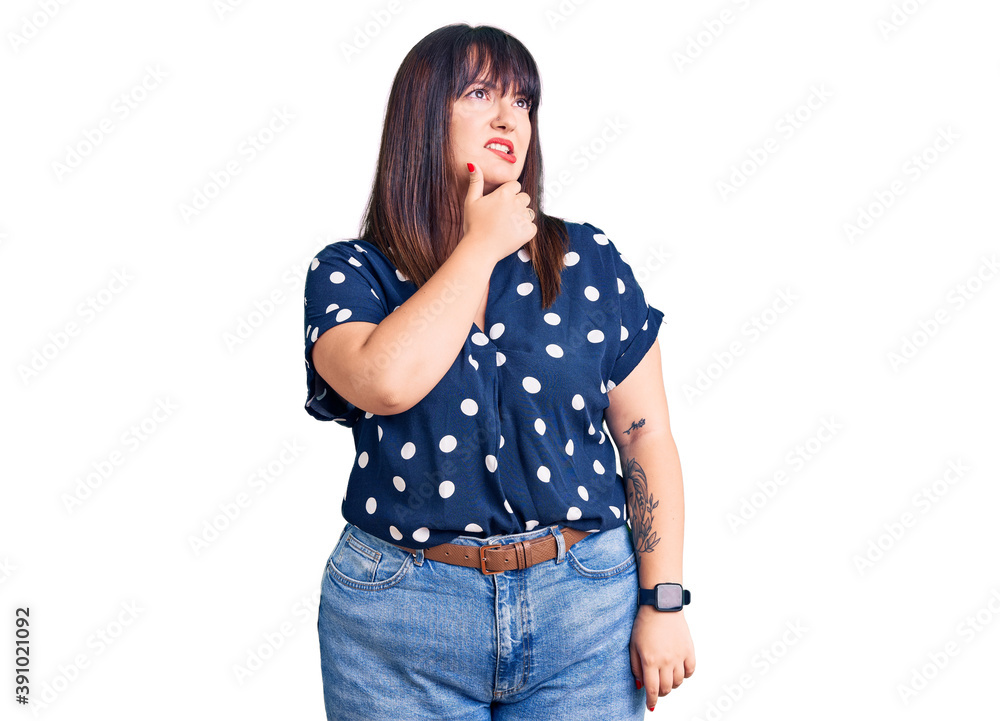 Young plus size woman wearing casual clothes thinking worried about a question, concerned and nervous with hand on chin Young plus size woman wearing casual clothes thinking worried about a question, concerned and nervous with hand on chin
