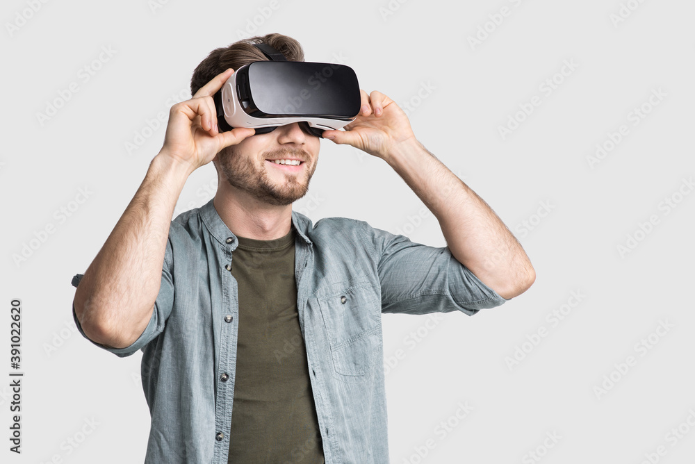 Handsome young man using virtual reality headset isolated on gray background, VR, future, gadgets, technology concept Handsome young man using virtual reality headset isolated on gray background, VR, future, gadgets, technology concept