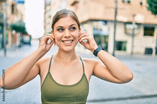 Young blonde sportswoman wearing sportswear doing exercise at the city.