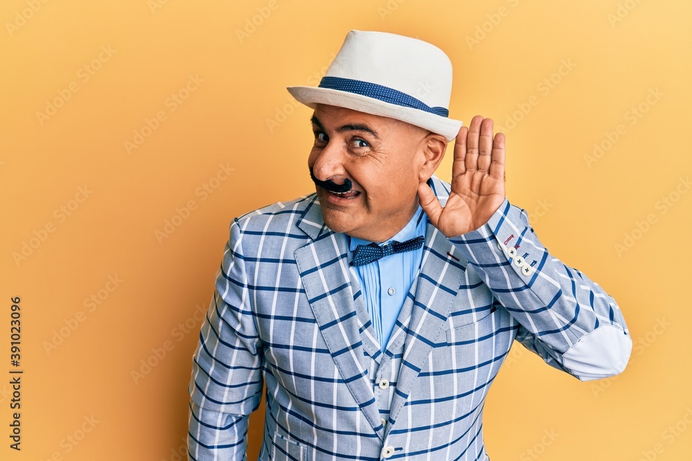 Mature middle east man with mustache wearing vintage and elegant fashion style smiling with hand over ear listening an hearing to rumor or gossip. deafness concept.