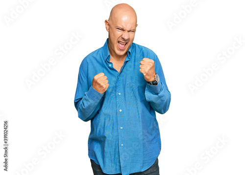 Middle age bald man wearing casual clothes celebrating surprised and amazed for success with arms raised and eyes closed. winner concept. © Krakenimages.com