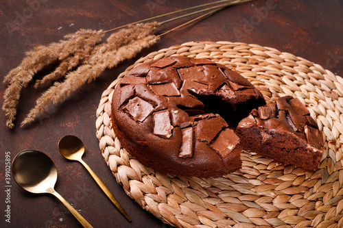 Chocolate cake with chocolate pieces on a brown background