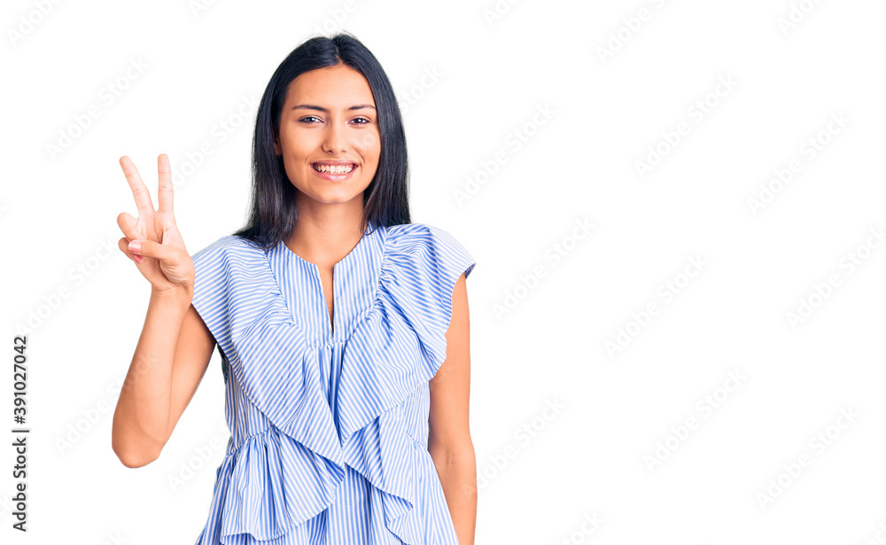 Young beautiful latin girl wearing casual clothes showing and pointing up with fingers number two while smiling confident and happy. Young beautiful latin girl wearing casual clothes showing and pointing up with fingers number two while smiling confident and happy.
