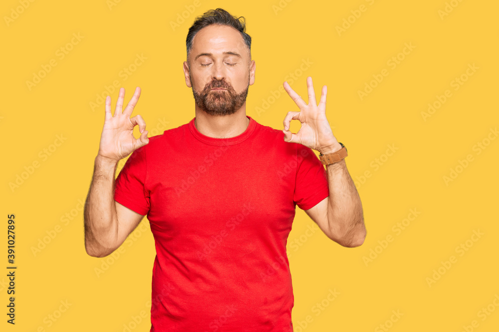 Fototapeta premium Handsome middle age man wearing casual red tshirt relax and smiling with eyes closed doing meditation gesture with fingers. yoga concept.