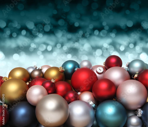 Christmas decorations, pile of glass colored balls isolated on blurred blue bright lights, useful as a greeting gift card background