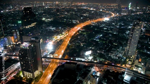 BANGKOK, THAILAND - DECEMBER 15, 2019: Aerial view of city skyline at night with street traffic and skyscrapers