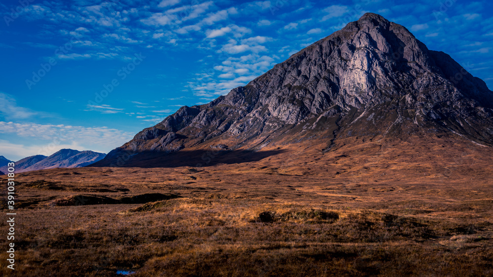 Detailed mountain set against a bright blue sky on an autumn day at Buachaille Etive Mor Glen Coe Scotland