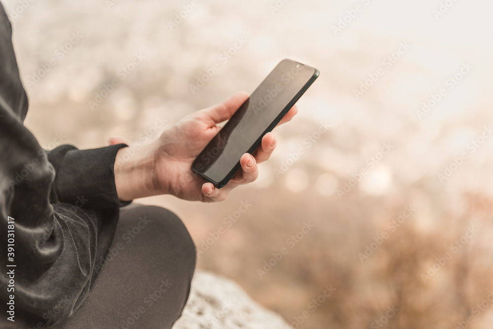 Closeup image of female hands using smartphone in mountain day, search or social network concept, hipster woman typing a sms message to her friends