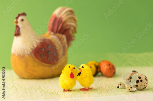 Easter concept. Inrushka chicken with chickens on a green background. Nearby eggshell