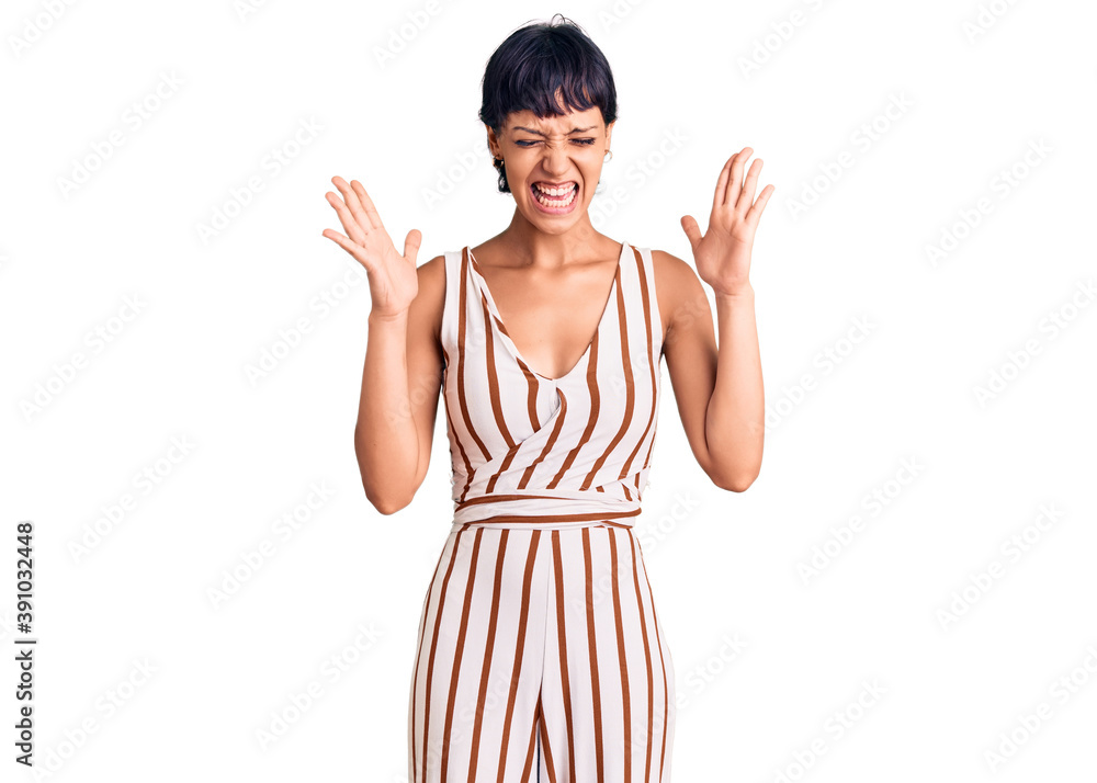 Young brunette woman with short hair wearing summer outfit celebrating mad and crazy for success with arms raised and closed eyes screaming excited. winner concept Young brunette woman with short hair wearing summer outfit celebrating mad and crazy for success with arms raised and closed eyes screaming excited. winner concept