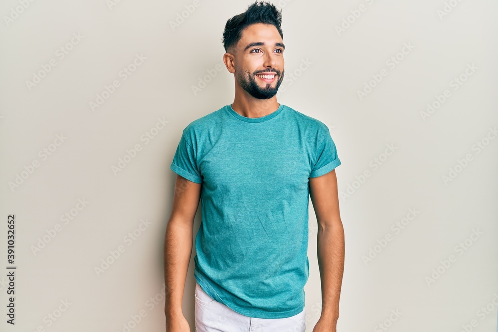Young man with beard wearing casual clothes looking to side, relax profile pose with natural face and confident smile. Young man with beard wearing casual clothes looking to side, relax profile pose with natural face and confident smile.