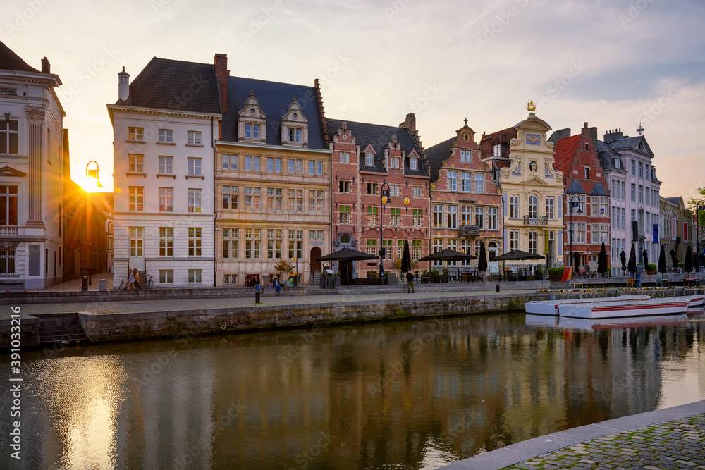 View of Korenlei quay and Leie river in the historic city center in Ghent (Gent), Belgium. Architecture and landmark of Ghent. Sunset cityscape of Ghent.