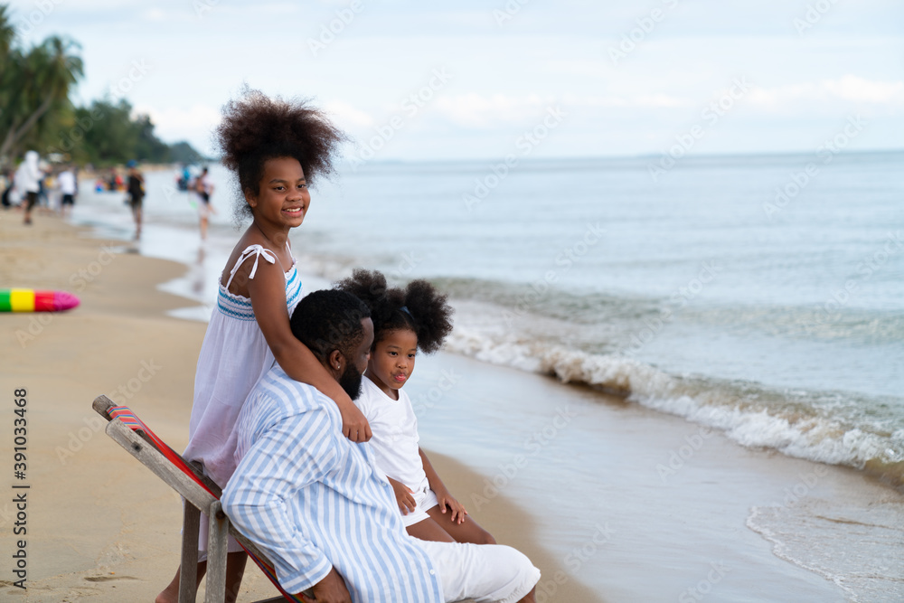 Happy family with two kids and black daddy in beach chair  hugging and playing together , Concept for travel family happy on beach