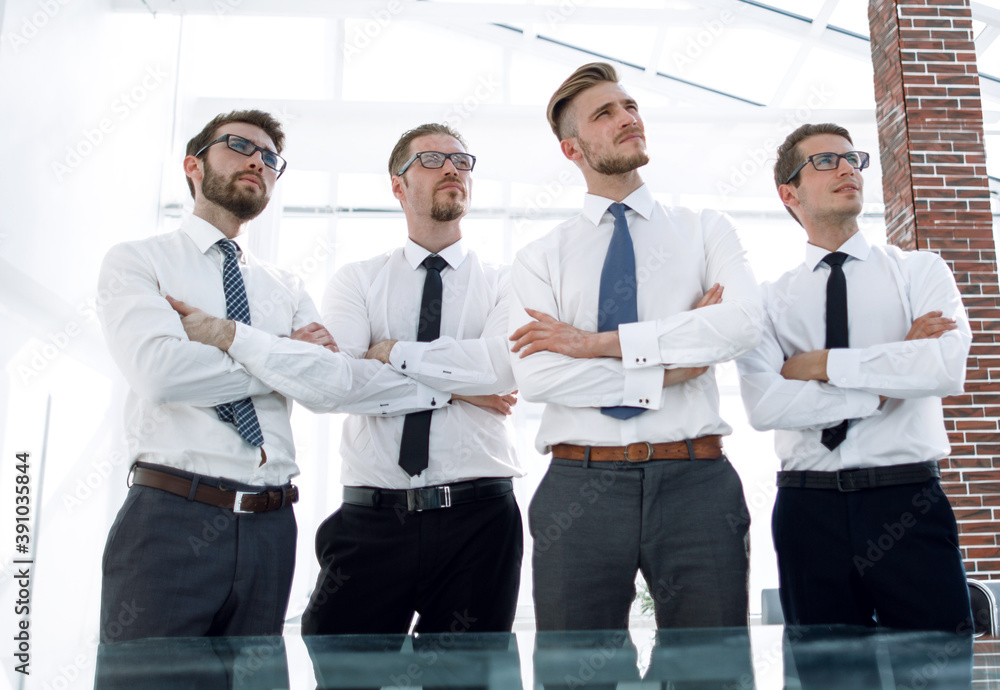 group of employees standing in an office and looking at a copy space group of employees standing in an office and looking at a copy space