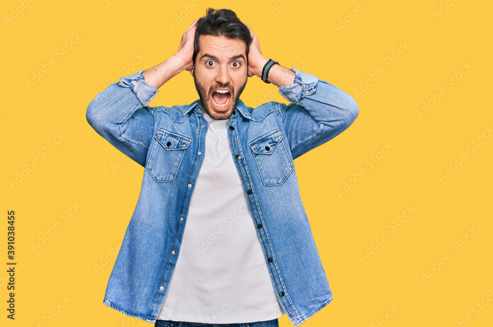 Young hispanic man wearing casual clothes crazy and scared with hands on head, afraid and surprised of shock with open mouth Young hispanic man wearing casual clothes crazy and scared with hands on head, afraid and surprised of shock with open mouth