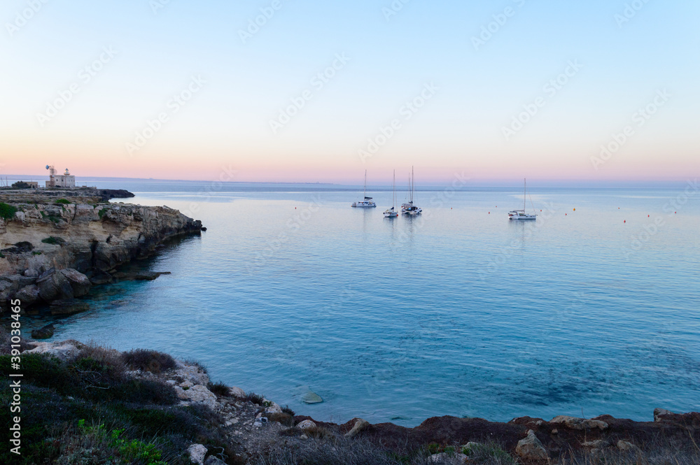 Cristal clear water and no people at the famous Cala Azzurra in Favignana, Italy. A perfect calm sunrise in this paradise island in the mediterranean sea