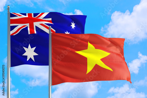 Vietnam and Australia national flag waving in the windy deep blue sky. Diplomacy and international relations concept.