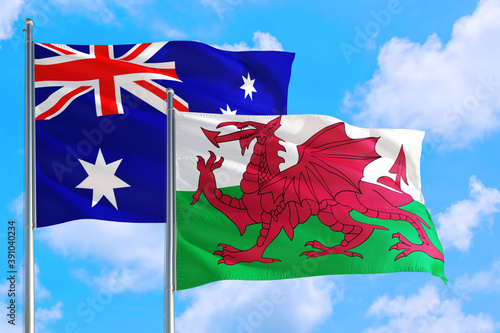 Wales and Australia national flag waving in the windy deep blue sky. Diplomacy and international relations concept.