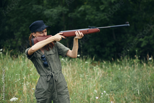 Woman With weapons in hand, nature takes aim green overalls 