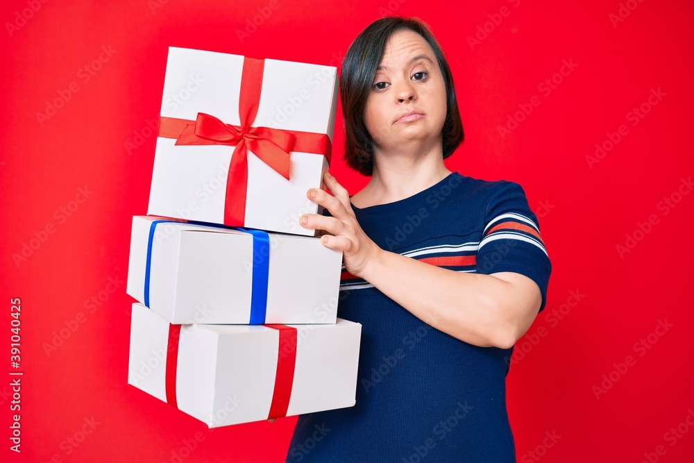 Brunette woman with down syndrome holding gifts clueless and confused expression. doubt concept. Brunette woman with down syndrome holding gifts clueless and confused expression. doubt concept.