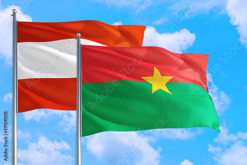 Burkina Faso and Austria national flag waving in the windy deep blue sky. Diplomacy and international relations concept.