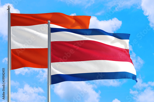 Costa Rica and Austria national flag waving in the windy deep blue sky. Diplomacy and international relations concept.