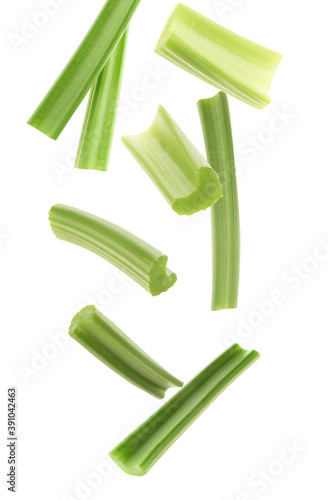 Cut fresh green celery falling on white background
