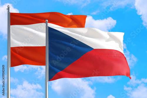 Czech Republic and Austria national flag waving in the windy deep blue sky. Diplomacy and international relations concept.