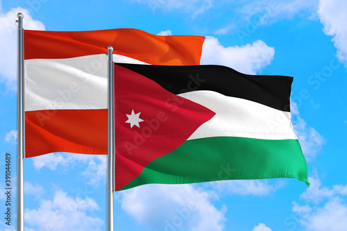 Jordan and Austria national flag waving in the windy deep blue sky. Diplomacy and international relations concept.