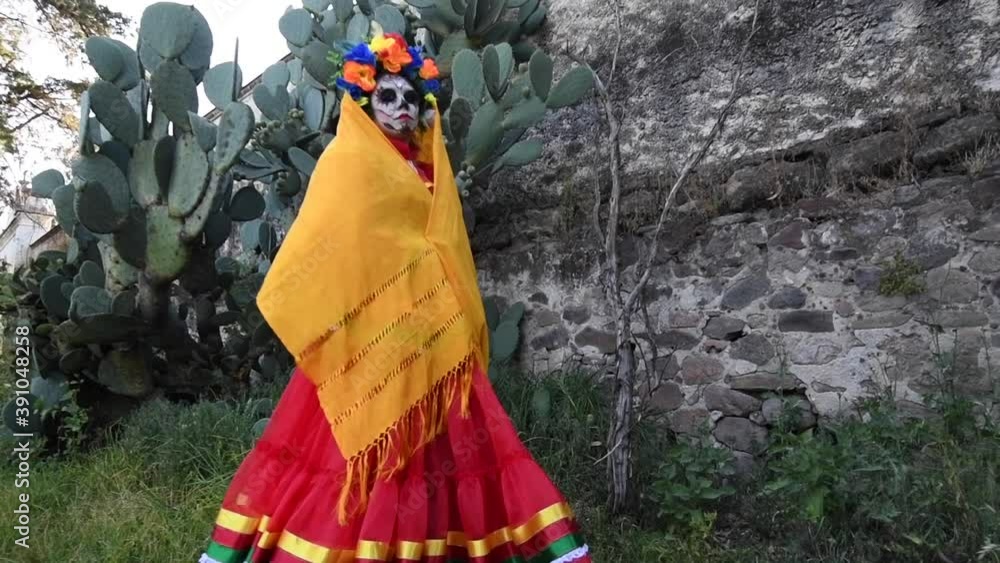 Woman disguised as catrina, walking with yellow overflow for the day of the dead Woman disguised as catrina, walking with yellow overflow for the day of the dead