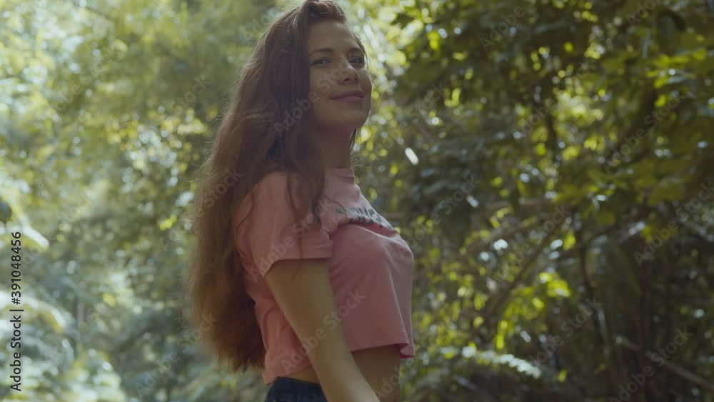 Venezuelan girl plays in her hair while enjoying a tropical park atmosphere