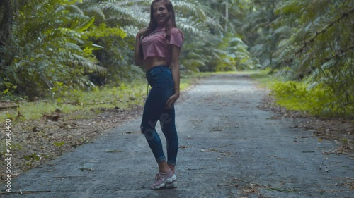 Sexy latina young girl walking away then turns around at this amazing tropical park photo