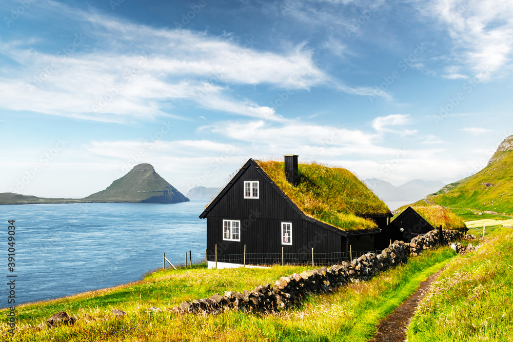 Foggy morning view of a house with typical turf-top grass roof in the Velbastadur village on Streymoy island, Faroe islands, Denmark. Landscape photography Foggy morning view of a house with typical turf-top grass roof in the Velbastadur village on Streymoy island, Faroe islands, Denmark. Landscape photography